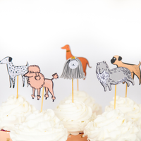 Close-up of illustrated puppy cake toppers on cupcakes