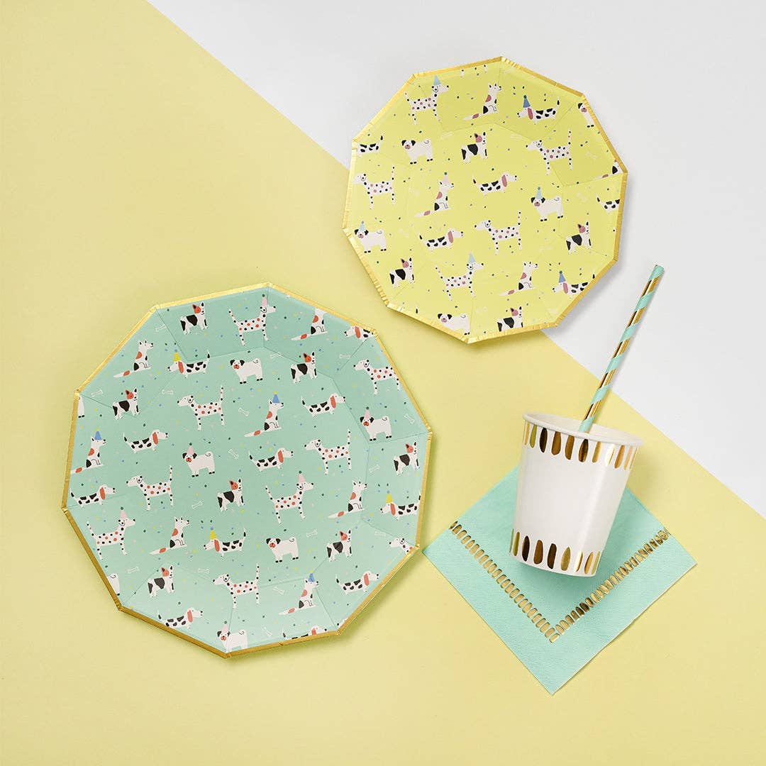 Mint and yellow dog themed party plates stacked on table with drinks.