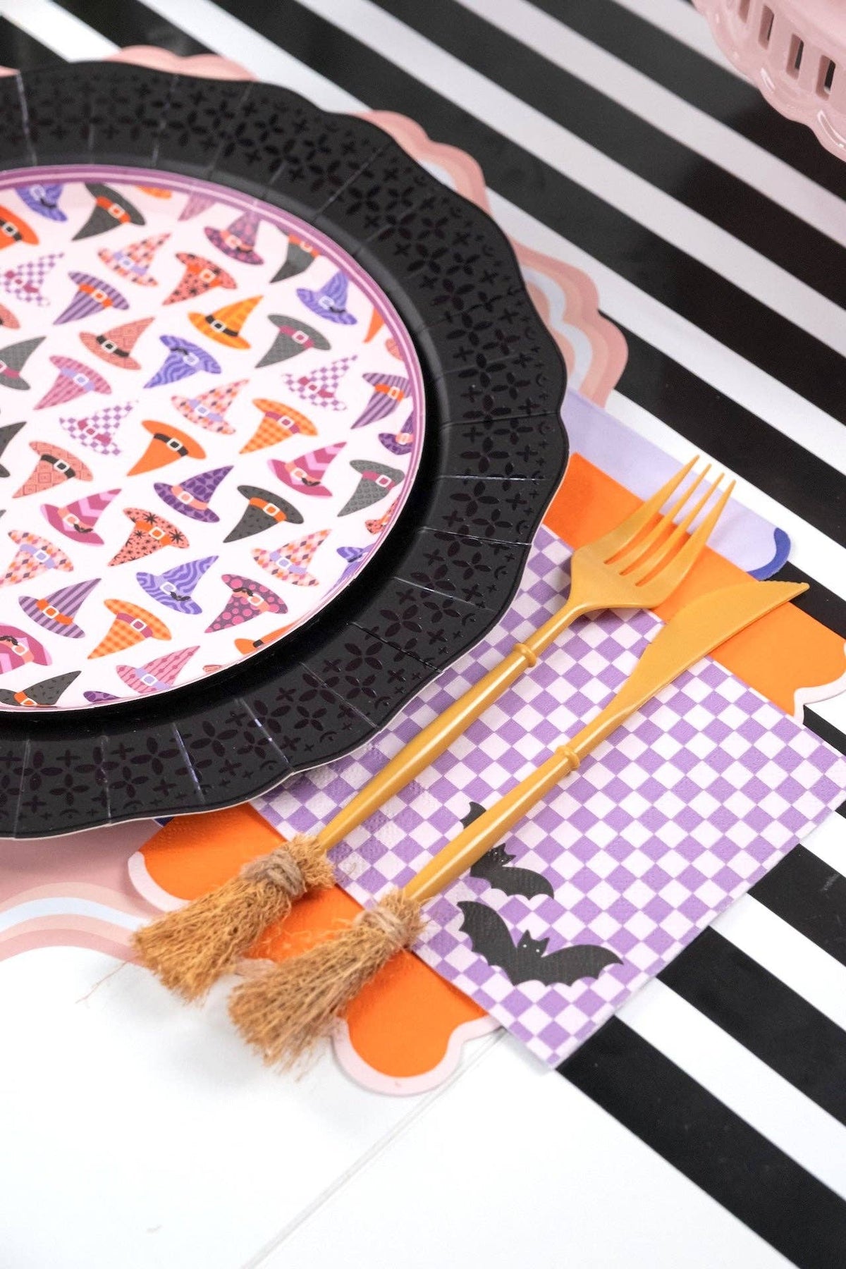 Lavender checkered bat napkin layered with an orange scalloped napkin and gold fork and knife
