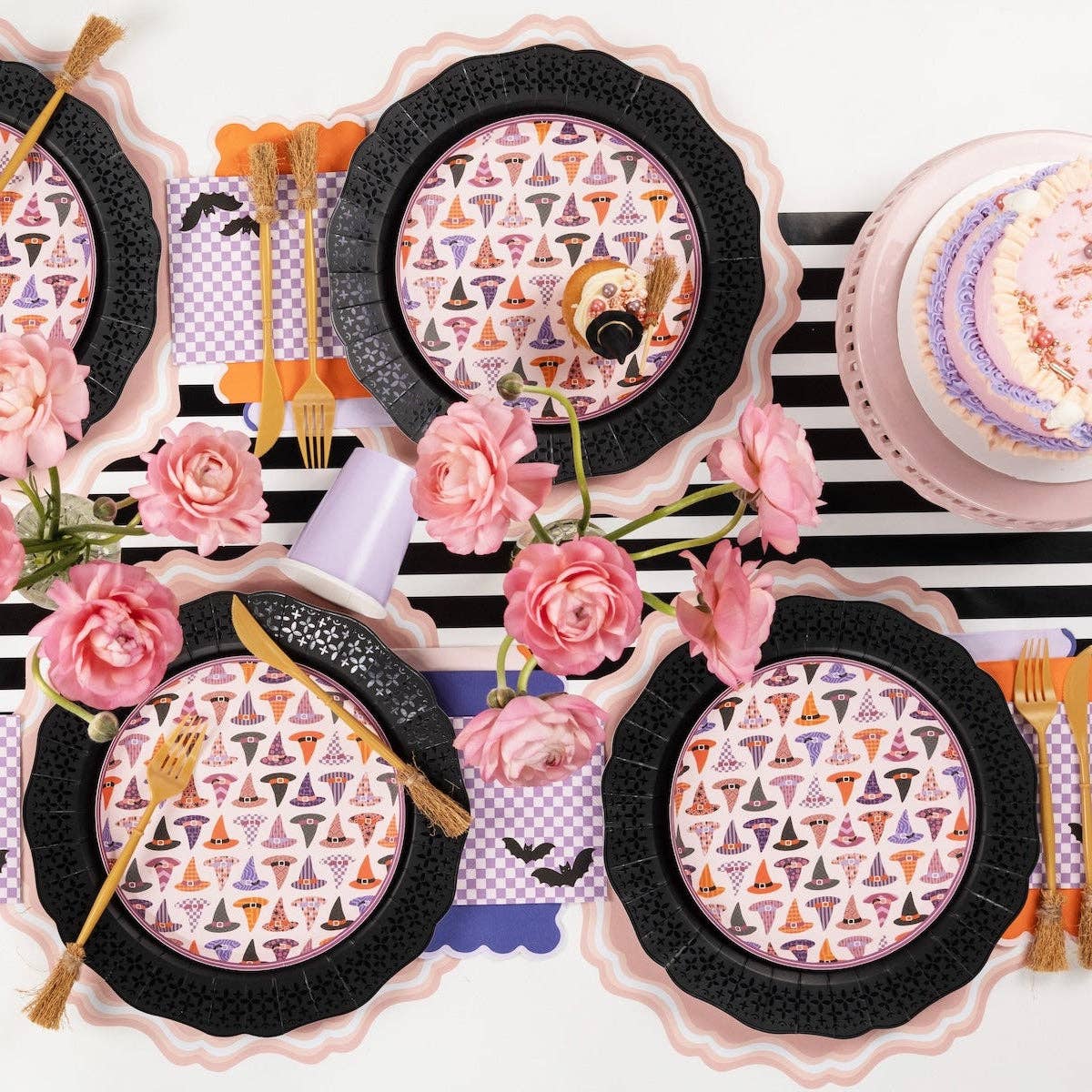 Purple checkered bat napkins styled with black scalloped charger plates and gold flatware on a striped runner
