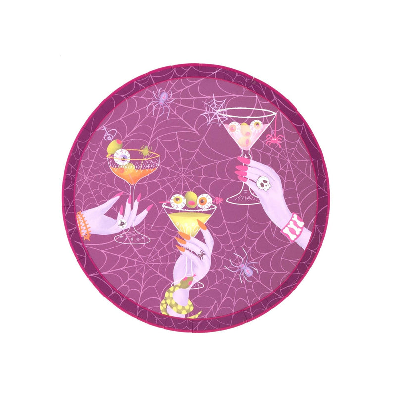 Overhead studio shot of a 7 inch round purple paper dessert plate featuring white spiderwebs and manicured hands holding eyeball martinis.
