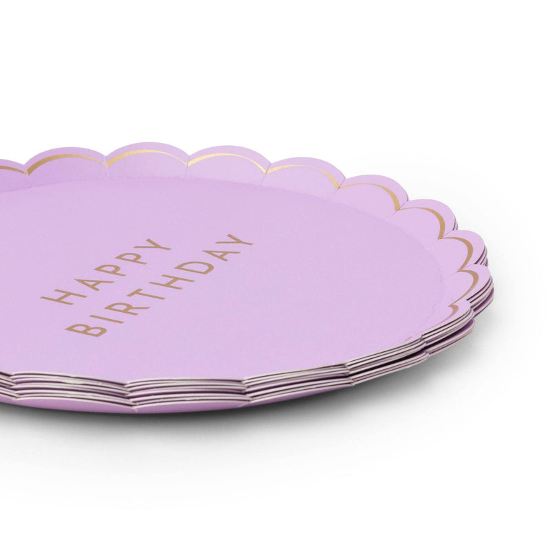 Angled stack of lilac scalloped plates showing the gold-foil lettering, thin gold rim, and the full set depth.