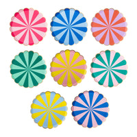Eight rainbow stripe scalloped paper party plates in different colors arranged together