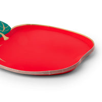 Close-up side view of stack of red apple shaped paper plates showing the apple silhouette, green leaf detail, gold foil edge, and paper construction