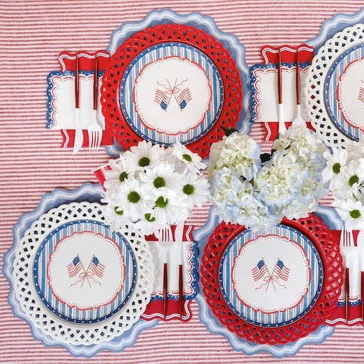 red textured paper plates layered with patriotic table setting and patterned plates.