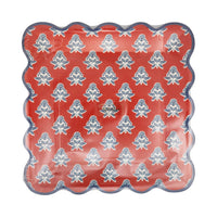 Red block print floral scalloped paper plate with blue and cream floral motif and navy scalloped edge shown in packaging