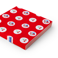 Angled view of stacked red cherry and floral polka dot luncheon napkins showing alternating cherry and flower motifs in white circles on red background