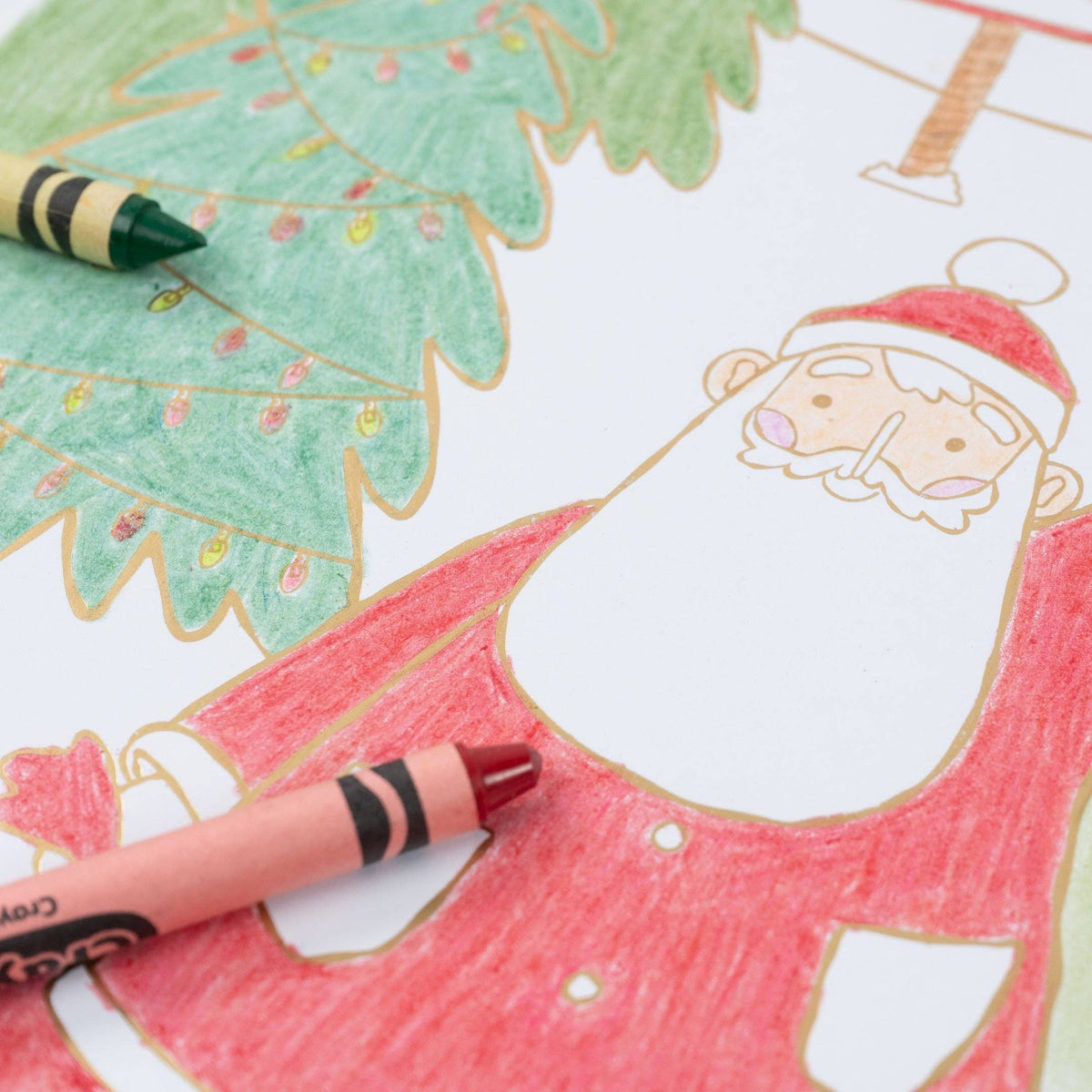 Extreme close-up of a red crayon resting on a partially colored Santa illustration.