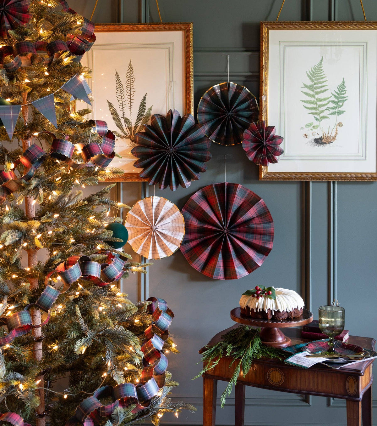 Plaid Christmas paper fans styled on a wall above a console