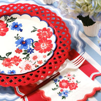 red basketweave plates styled in table setting with striped linens and florals.