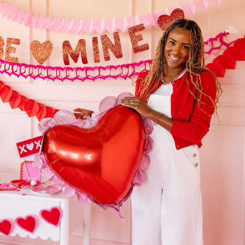 Large red heart balloon with pink scalloped edge displayed at a Valentine setup