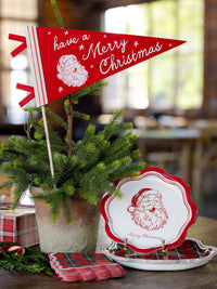 Red Santa felt pennant in a potted tree on a table