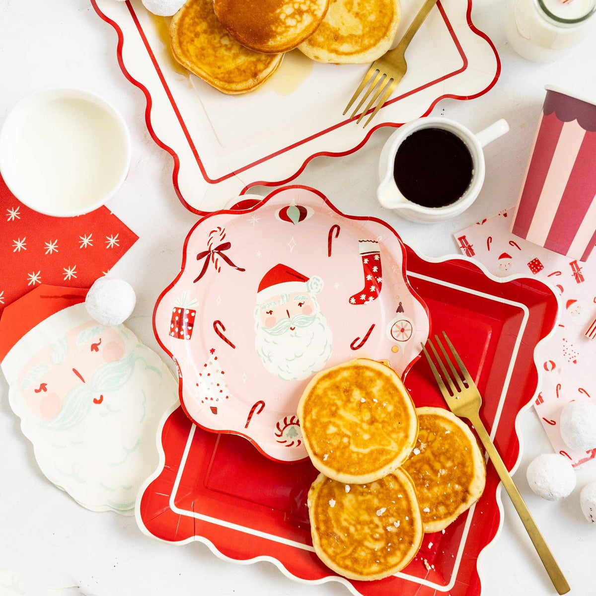 Red plate styled on holiday breakfast table with pancakes and Santa tableware