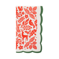 Cream paper dinner napkin with a red folk art print of a cardinal, deer, squirrel, pinecones, and poinsettias and a green scalloped edge