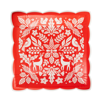 Red square paper plate with a cream woodland folk art design of deer, cardinals, squirrels, and pinecones and a cream scalloped edge