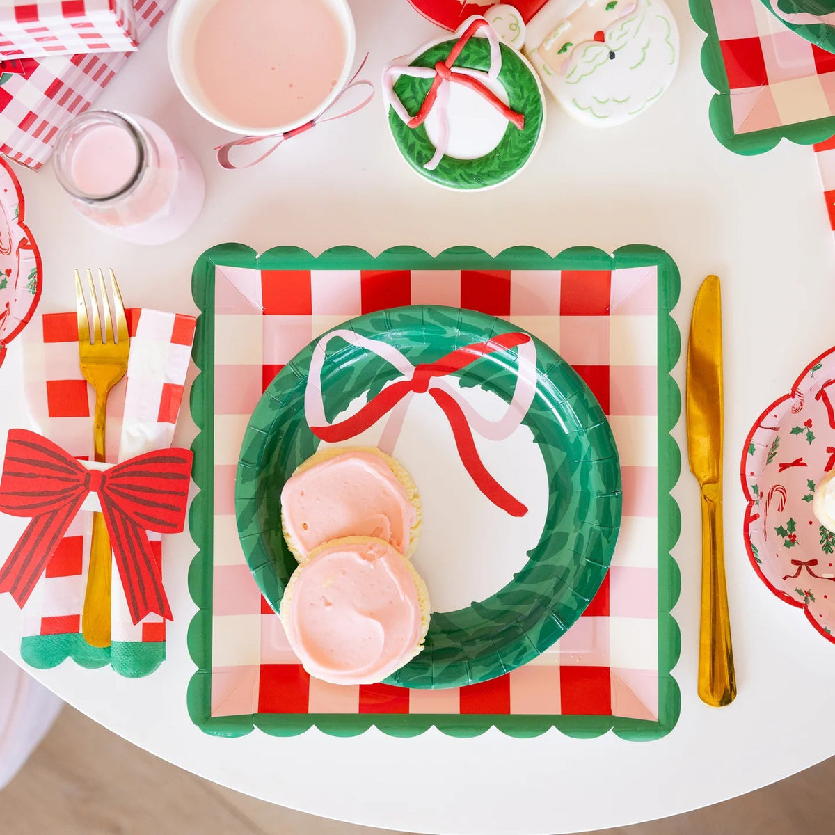 Detailed overhead shot of a single place setting showing the layered plates and the red plaid napkins with the bow band.