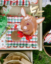 Reindeer shaped paper plate with a gingerbread cookie on a gingham square plate; gingham plate, fork, napkins, and piping bag shown separately, not included