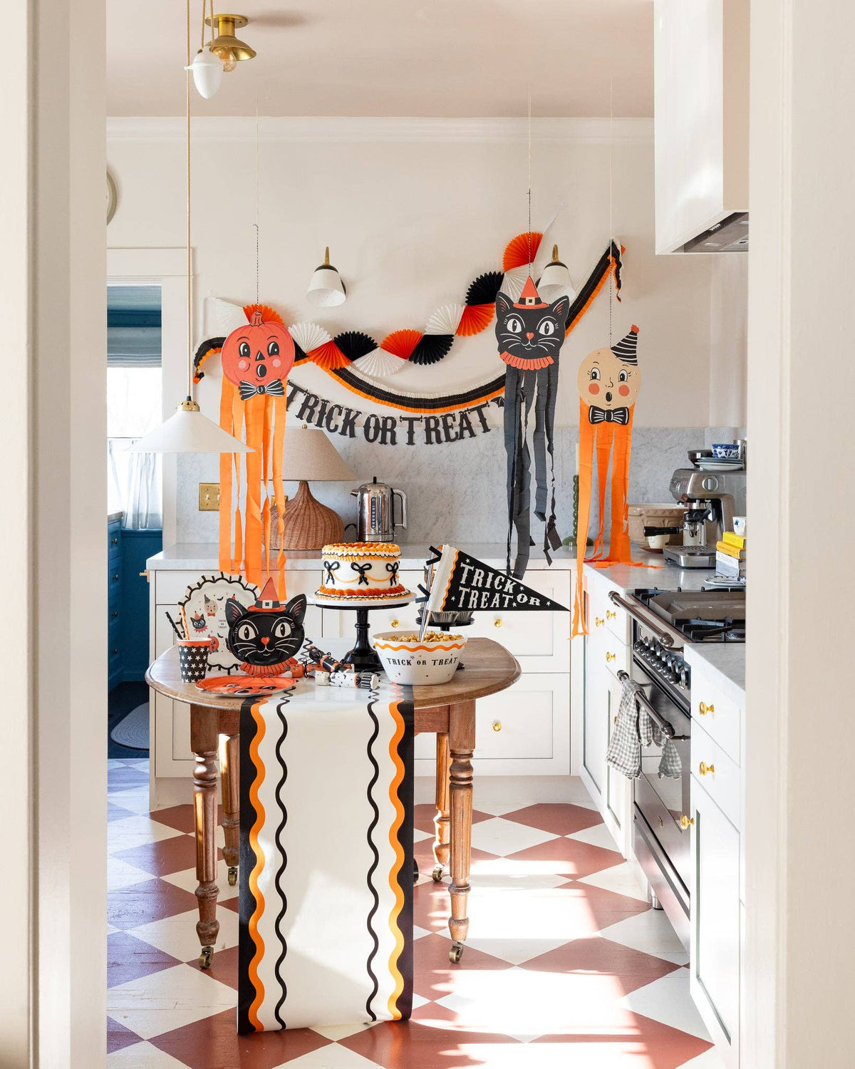 Halloween-themed kitchen with decorative pumpkins and 'Happy Halloween' banner along the ric rac table runner