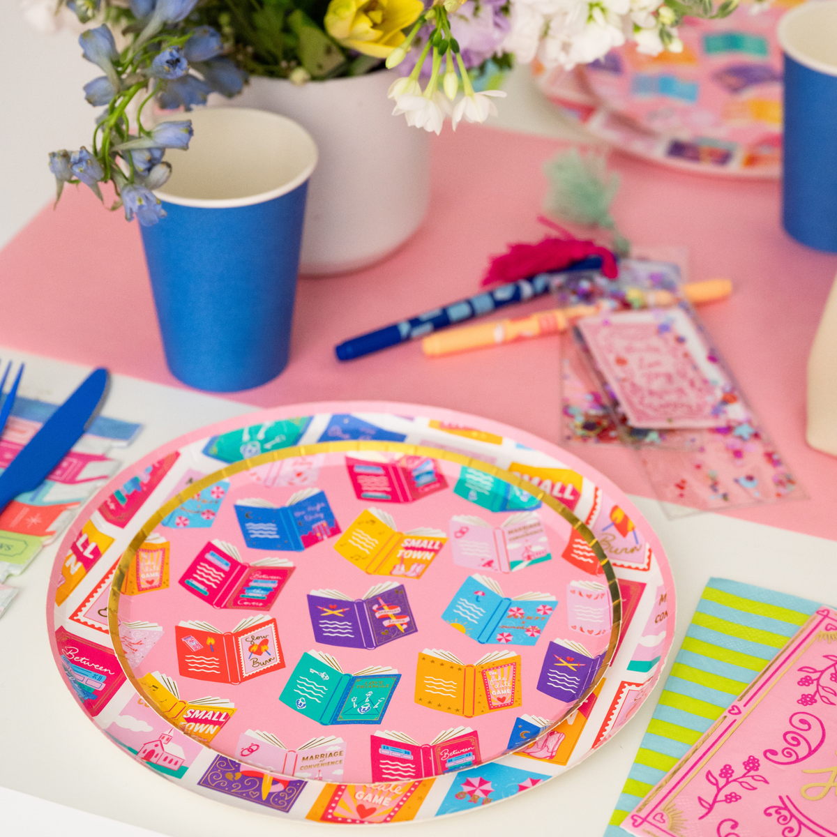 romcom party table setup with book print dessert plates