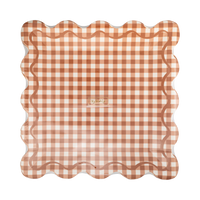 Stack of 8 rust gingham square charger plates with scalloped edge on a clear packaging, front view.