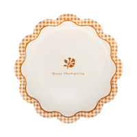 Overhead view of 9 inch rust gingham Happy Thanksgiving paper dinner plate with gold foil script against cream background.