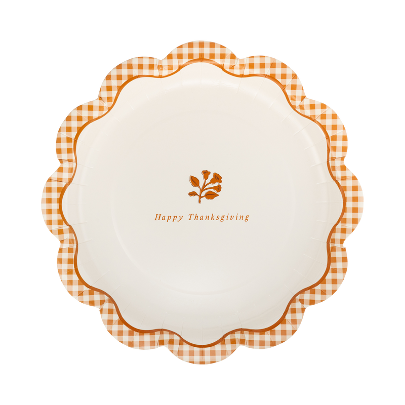 Overhead view of 9 inch rust gingham Happy Thanksgiving paper dinner plate with gold foil script against cream background.