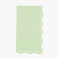 Solid sage green guest towel with a flowing scalloped white-outlined edge, flat view on white background.