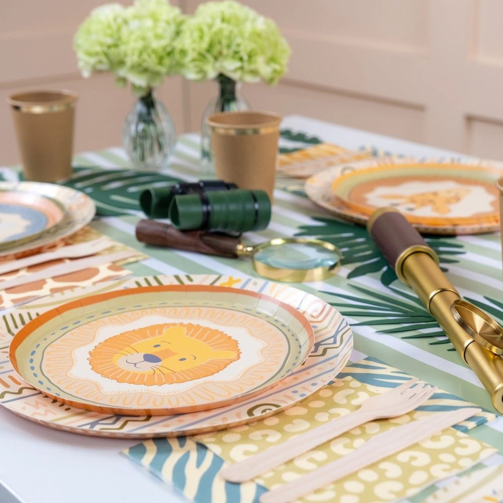 sage green paper table runner with safari party table decor and lion plate.