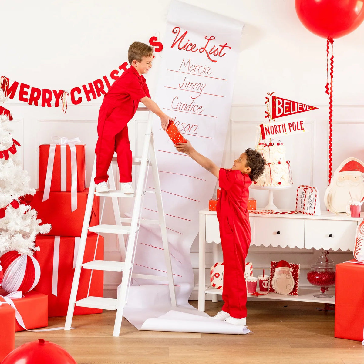 Holiday vignette with Nice List backdrop and assembled Santa Christmas cookie boxes on dessert table
