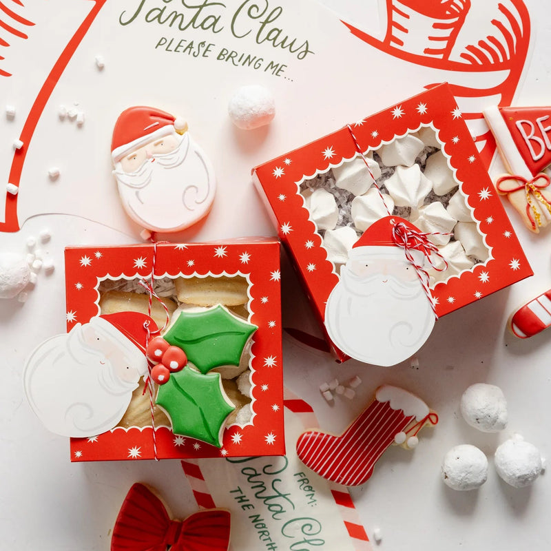 Overhead close-up of two assembled red window Christmas treat boxes with cookies and candy