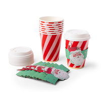 Group shot of the Santa cup set — striped cups, a stack of white lids, and green Santa sleeves laid out together.