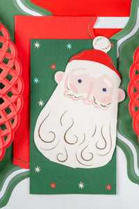 Close-up of a Santa-head napkin on the green star guest towel beside a red lattice charger.