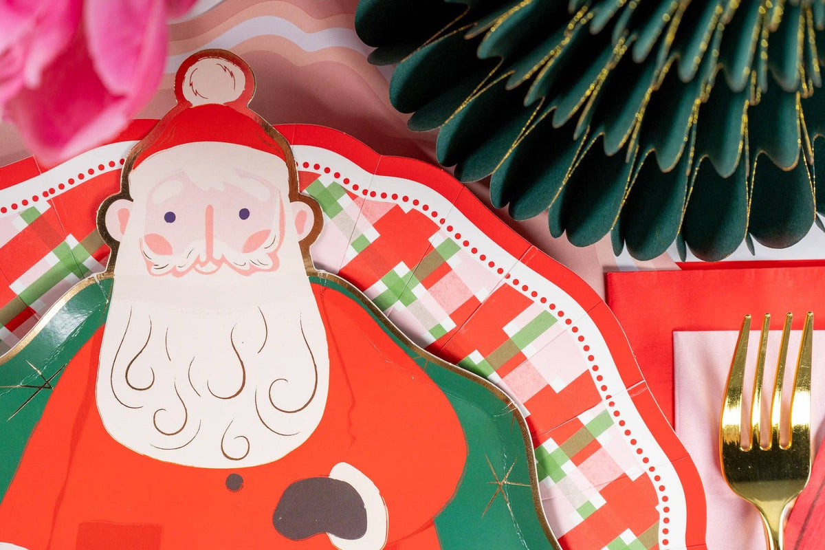 Close-up of a Santa plate layered on the plaid dinner plate beside a green fringe tree.