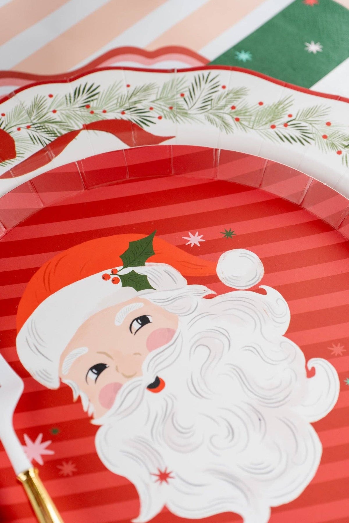 Close-up of the Santa dessert plate's candy-cane stripes, Santa face, and holly.
