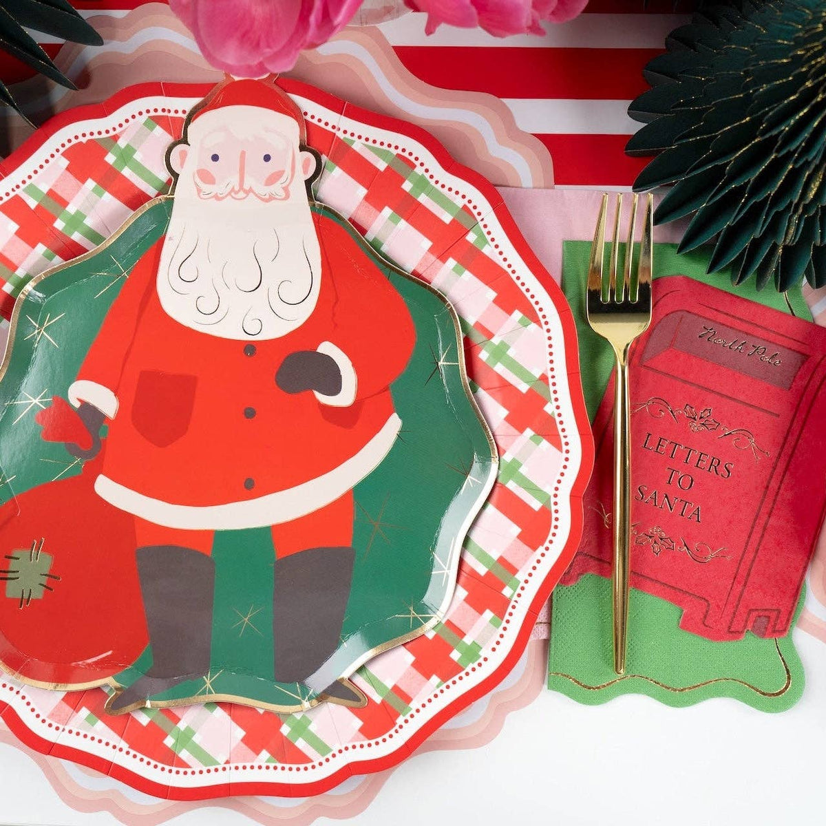 Place setting with a Santa plate on the plaid dinner plate, a green fringe tree, and a red "letters to Santa" napkin.