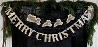 Close-up of Santa and flying reindeer on gold cord with glitter trim.
