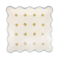 A stack of 8 Bee themed paper plates with a blue scalloped edge for a Sweet as can bee baby shower.