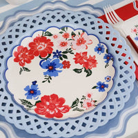 Close-up of an 8-inch Summer Floral Paper Plate on a red lattice-style charger.