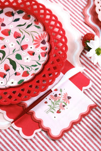 Detailed zoom of the red scalloped trim on a Strawberry Paper Plate next to a matching napkin.