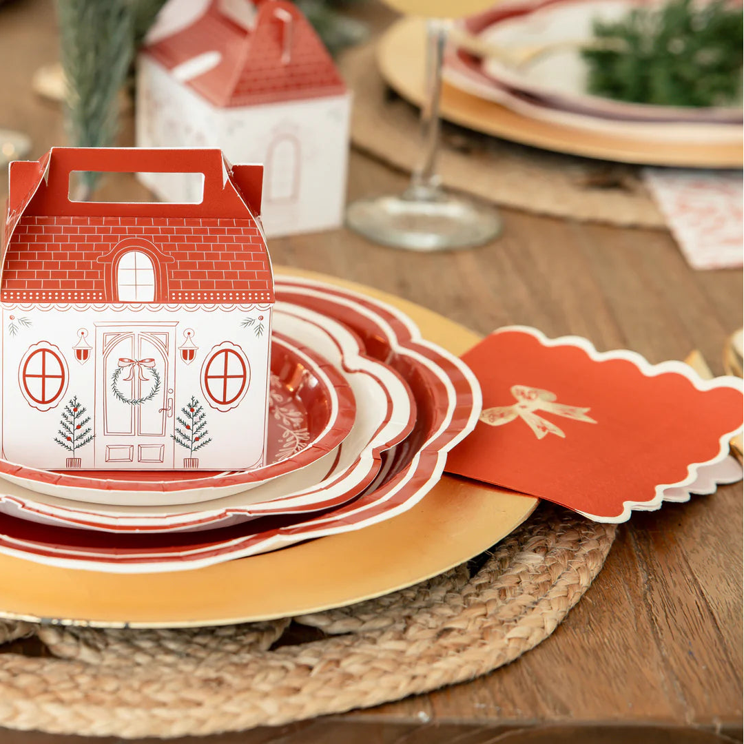 Close-up of the scalloped edge napkins placed at a formal holiday place setting with layered plates and a cottage treat box.