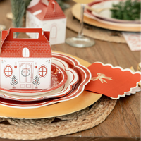 Close-up of the scalloped edge napkins placed at a formal holiday place setting with layered plates and a cottage treat box.