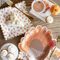 Slice of pie on scatter-pie plate beside gold flatware on a wood table.