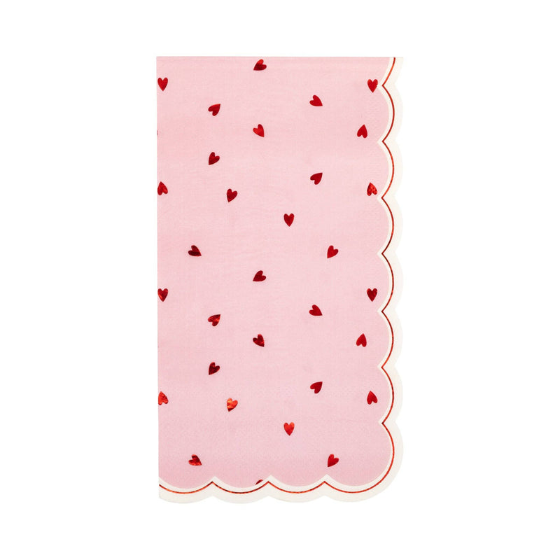 Pink dinner napkin with scattered red hearts and scalloped edge