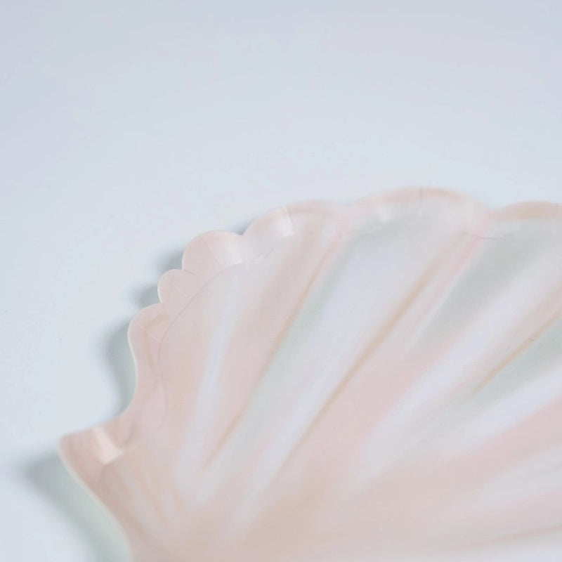 close up of seashell dessert plates with soft blush tones and scalloped edges.