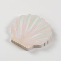 stack of seashell paper napkins showing shell shape and soft pastel tones.