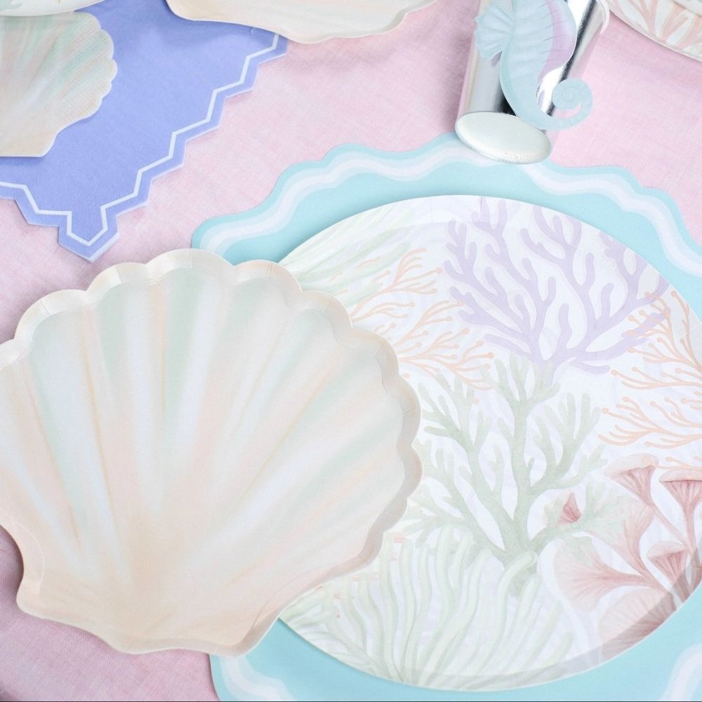 seashell dessert plates with mermaid party setup and pastel tableware.