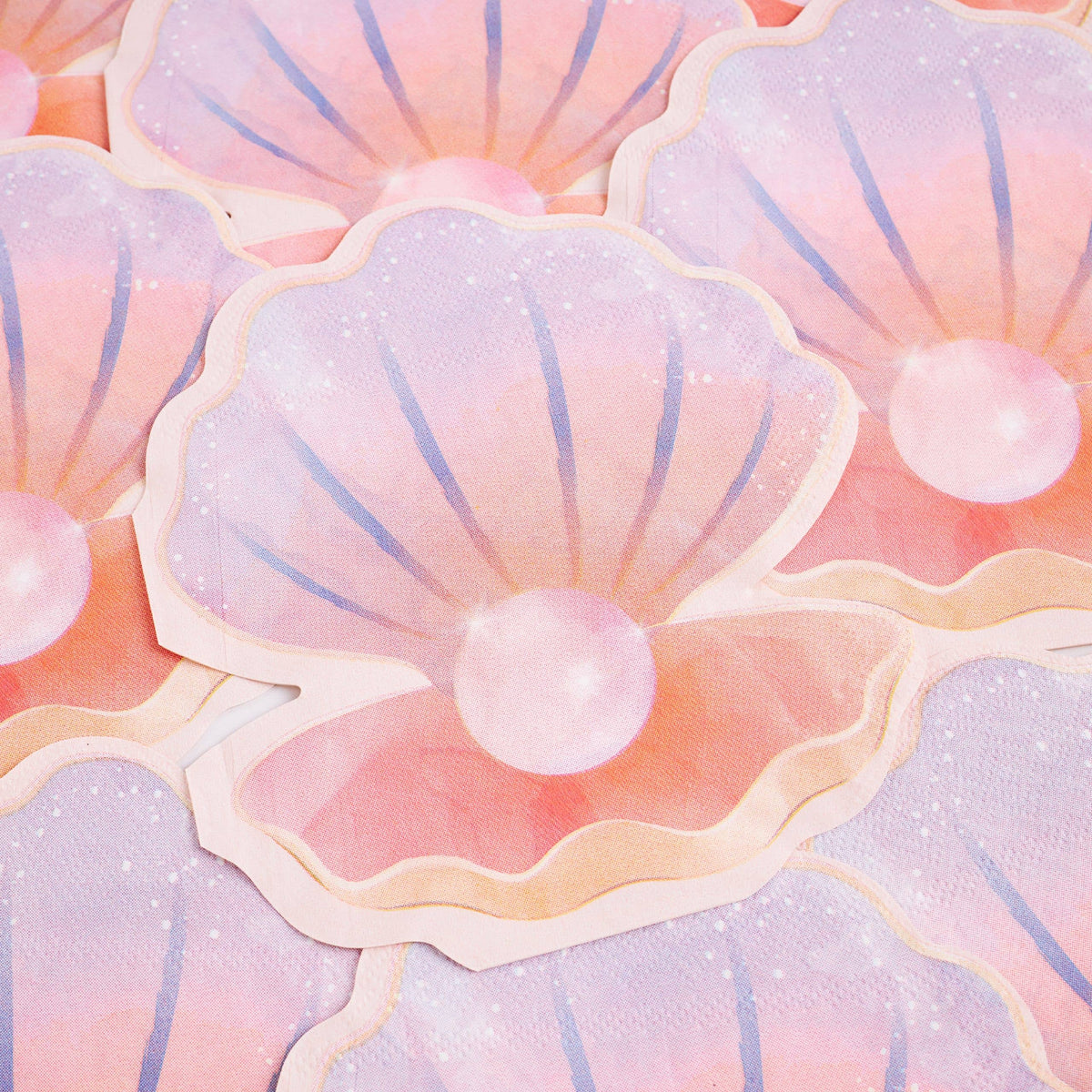 Stack of iridescent pastel seashell paper napkins showing the pearl and ombre