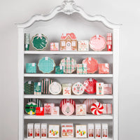 Full white shelf display showcasing all the Christmas paper plates and party supplies from the collection.