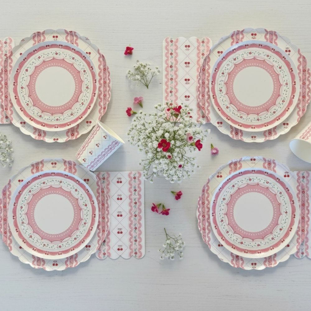 Symmetrical flat lay of four cherry place settings with floral centerpieces