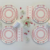 Symmetrical flat lay of four cherry place settings with floral centerpieces